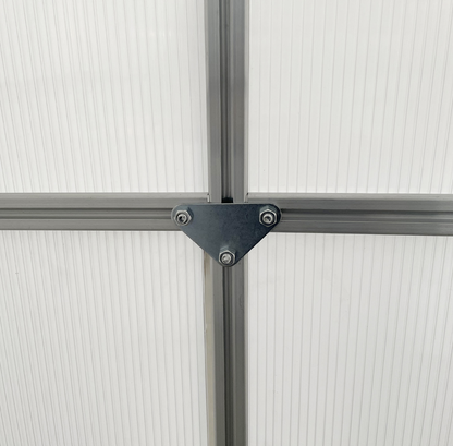 Close-up of a corner connection with metal brackets on a greenhouse