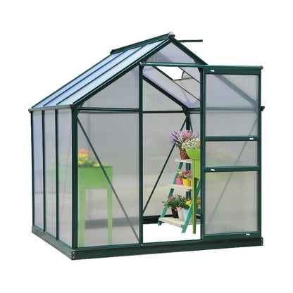 Greenhouse with transparent walls and a green frame, containing plants and gardening tools.