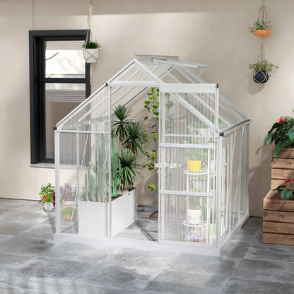 Small white greenhouse with plants inside, placed indoors on a gray floor.