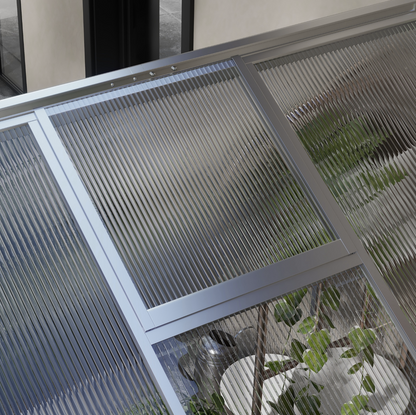 Glass window with metal frame and plant in the background